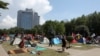 Pedestrians walk among tents set up by protesters in Gezi park, Taksim Square, Istanbul, June 6, 2013.