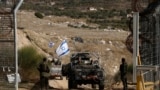 Israeli military vehicles cross the fence as they return from the buffer zone with Syria, near the Druze village of Majdal Shams in the Israel-annexed Golan Heights on December 10, 2024.