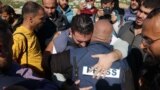 Al Jazeera's bureau chief in Gaza, Wael Al-Dahdouh (C) is comforted during the funeral of his son Hamza Wael Dahdouh, a journalist with the Al Jazeera television network, who was killed in a reported Israeli air strike, in Rafah in the Gaza Strip on Janua