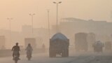 Commuters make their way amid heavy smog in Lahore on October 31, 2024.